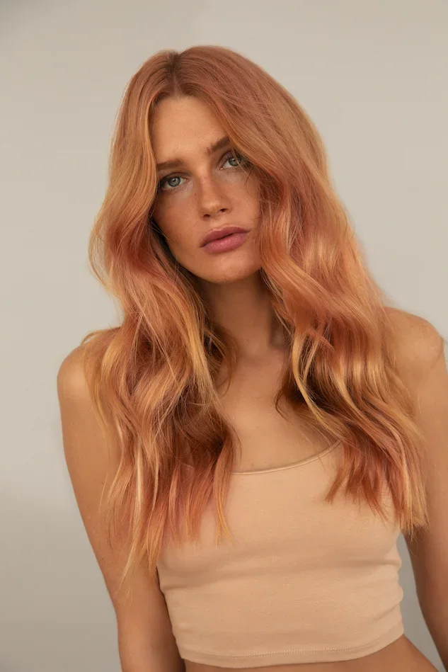 A model with long strawberry blonde waves, from the Artego Beauty Fusion campaign.