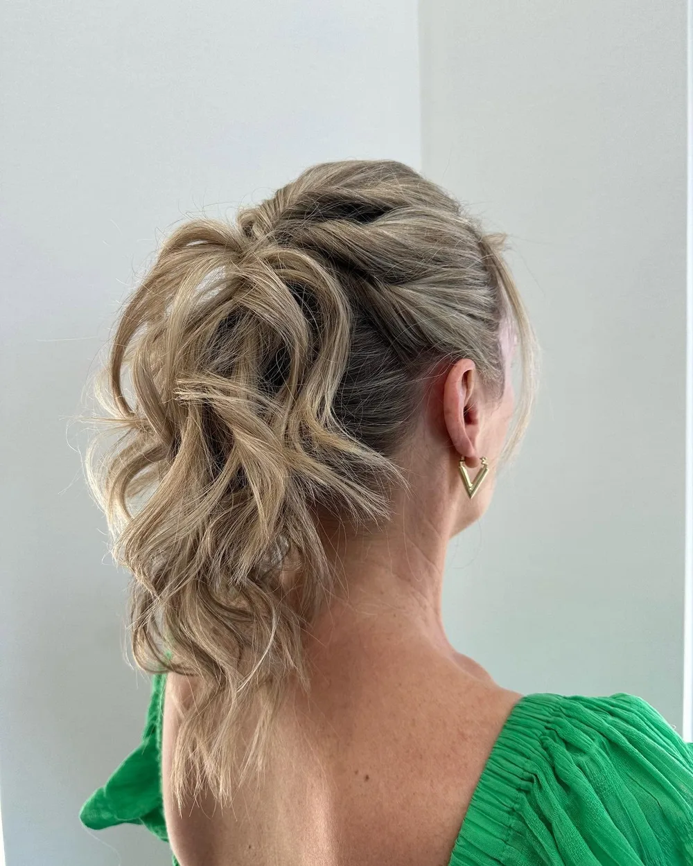 A soft textured upstyle with a curled ponytail and blonde highlights, finished at Cello Hairdressers in Five Dock.